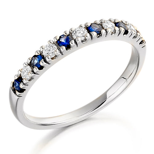 A half eternity ring with alternating blue sapphire and clear diamond stones set in a platinum band.