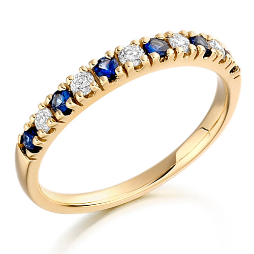 A half eternity ring with alternating blue sapphire and clear diamond stones set in a yellow gold band.