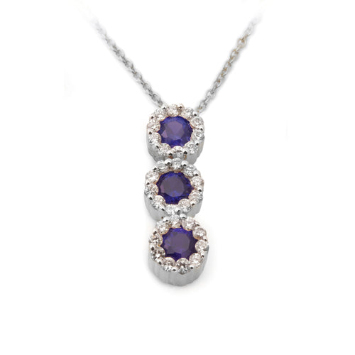 A Blue Sapphire Diamond Halo Journey Pendant with a vertical line of round blue sapphires encircled by diamond halos.