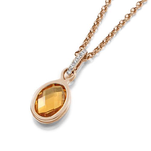 This Citrine Bezel Pendant features a faceted citrine in an oval shape, delicately held by a diamond bail in a rubover setting.