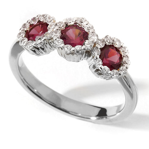 A Ruby Trilogy Ring with three red rubies set in a white gold band with halo diamonds around each ruby.