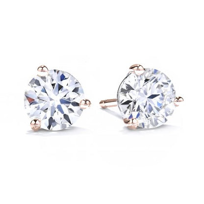 A pair of three claw solitaire earrings with round diamonds set in rose gold.