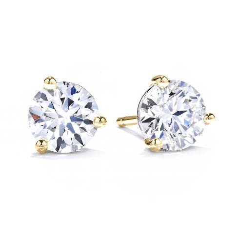 A pair of three claw solitaire earrings with round diamonds set in yellow gold.
